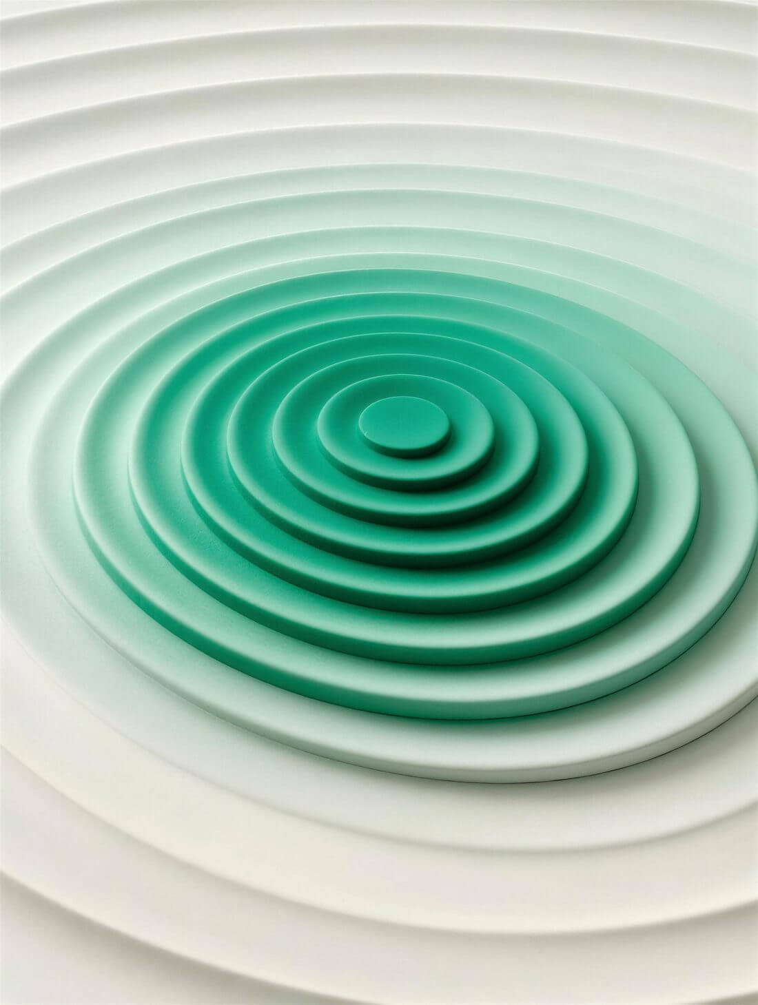 Concentric rings rippling outward across a smooth green and off-white surface.